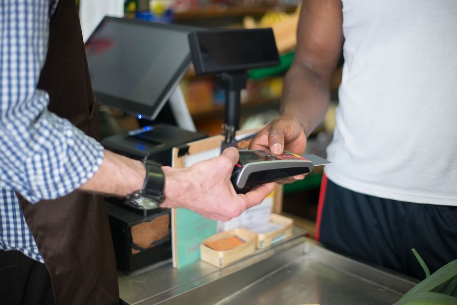 A customer paying by card at a store checkout